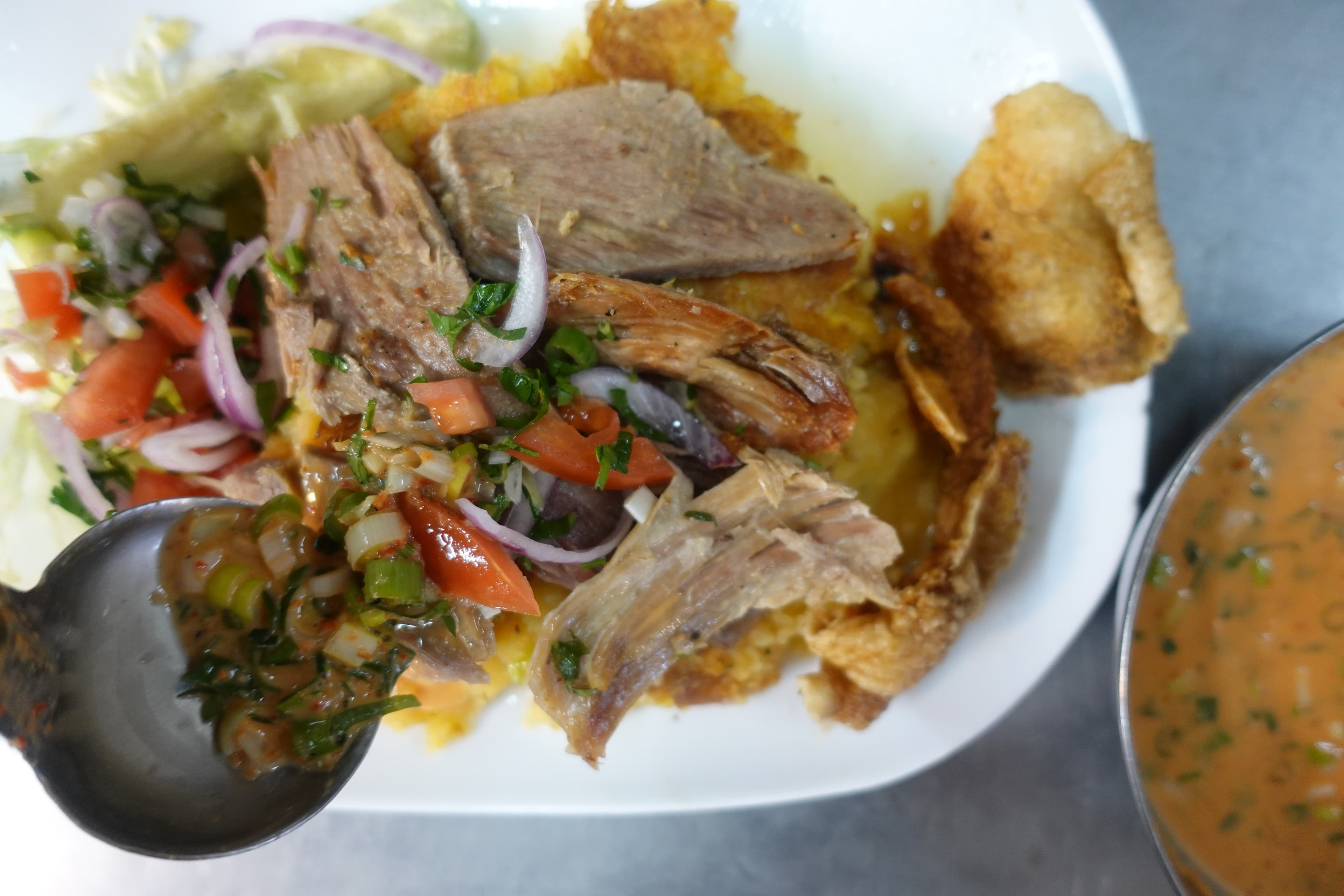Hornado served at a traditional hueca in a Quito market