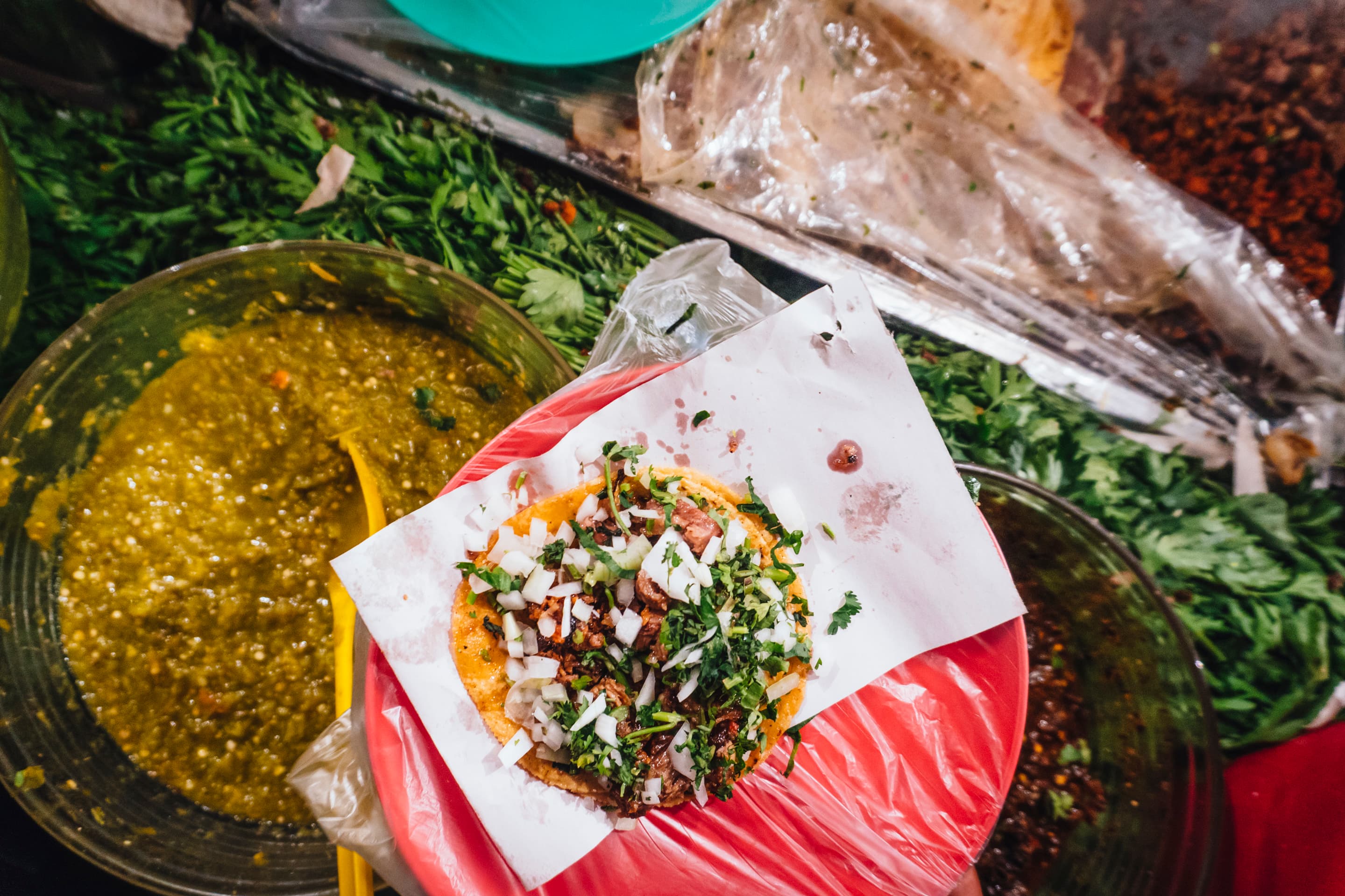 Tacos al pastor being served at a busy street food stand in Mexico City